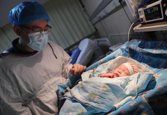 ↑2021年7月1日凌晨，在中国福利会国际和平妇幼保健院，一位爸爸在看自己的女儿。她是该院当日首名新生儿。