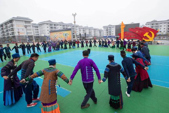 ↑2021年7月1日，在四川省布拖县易地扶贫搬迁县城集中安置点（依撒社区），彝族群众在广场上跳彝族达体舞。