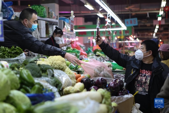 3月25日，在辽宁省沈阳市凤祥综合市场，一名市民买菜后扫码付款。新华社记者 王乙杰 摄