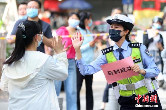 图为南京交警与考生击掌送祝福。 泱波 摄