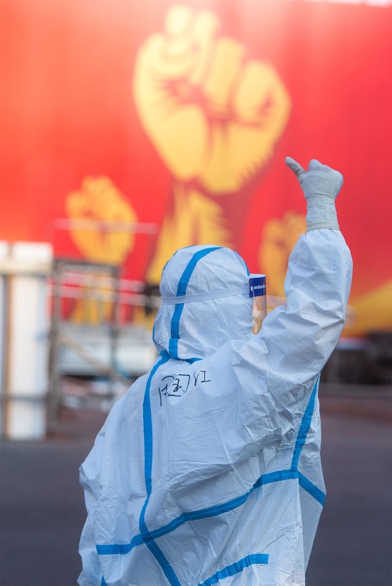 2020年2月12日，安徽援鄂医疗队队员周国红在湖北省武汉体育中心方舱医院前竖起拇指为自己和同伴加油鼓劲。新华社记者 肖艺九 摄