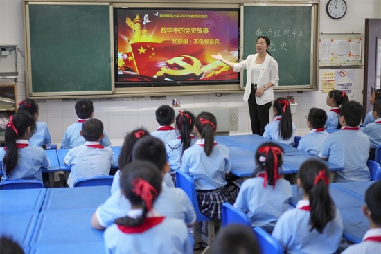 2022年5月5日，在重庆市九龙坡区铁路小学四年级二班的课堂上，数学老师牛俊懿通过讲述数学家华罗庚的故事开展党史教育活动。新华社记者 刘潺 摄
