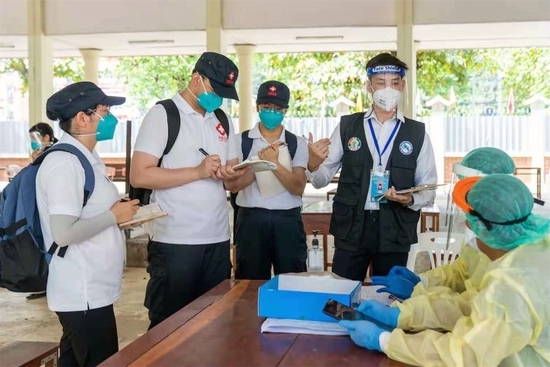 2021年5月7日，中国政府医疗专家组在老挝首都万象考察一个新冠病毒采样点，了解采样流程，信息采集，密切接触者判定标准和环境消毒等情况。新华社发（中国政府医疗专家组供图）