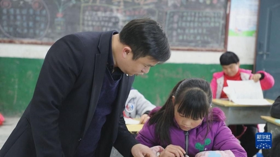 在湖南省常宁市塔山瑶族乡中心小学，盘玖仁在课堂上辅导学生（2021年11月25日摄）。新华社发（尹明 摄）