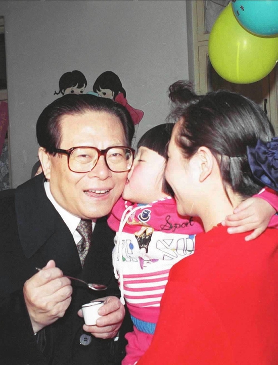  1993年12月5日，江泽民同志在北京为一位幼儿园儿童喂服脊髓灰质炎疫苗后，小朋友亲吻江爷爷。新华社发