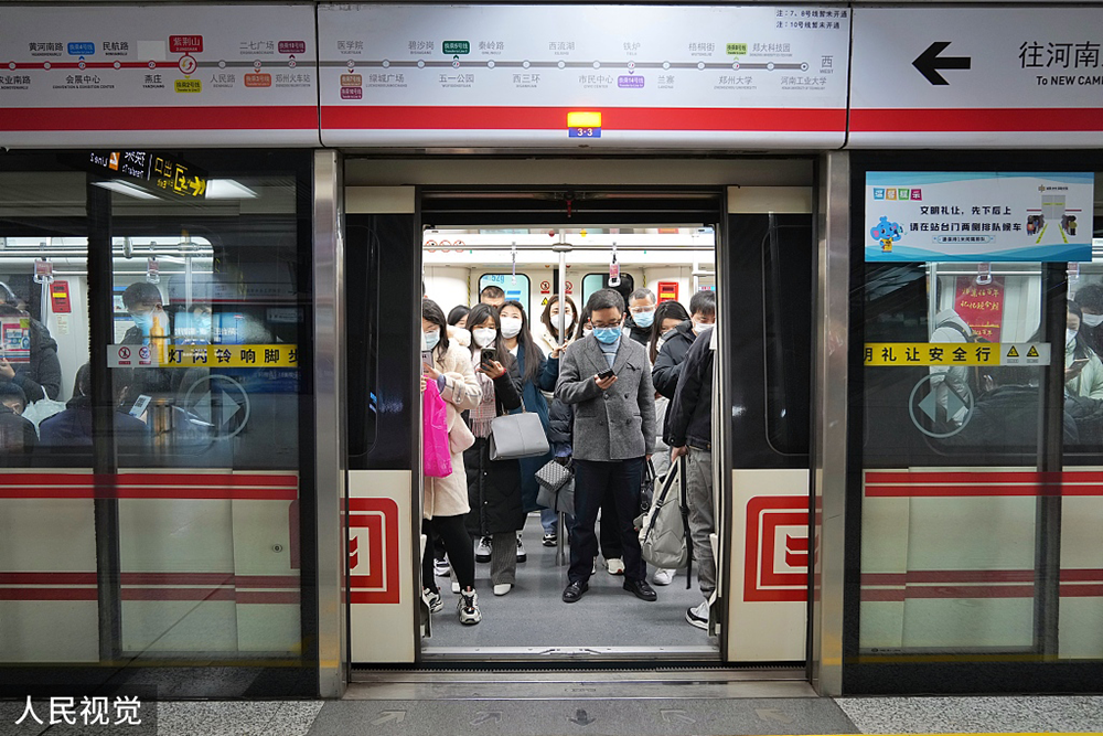 2022年12月5日，郑州，周一早高峰地铁人流量增加，市民戴口罩搭乘地铁有序出行。人民视觉  图