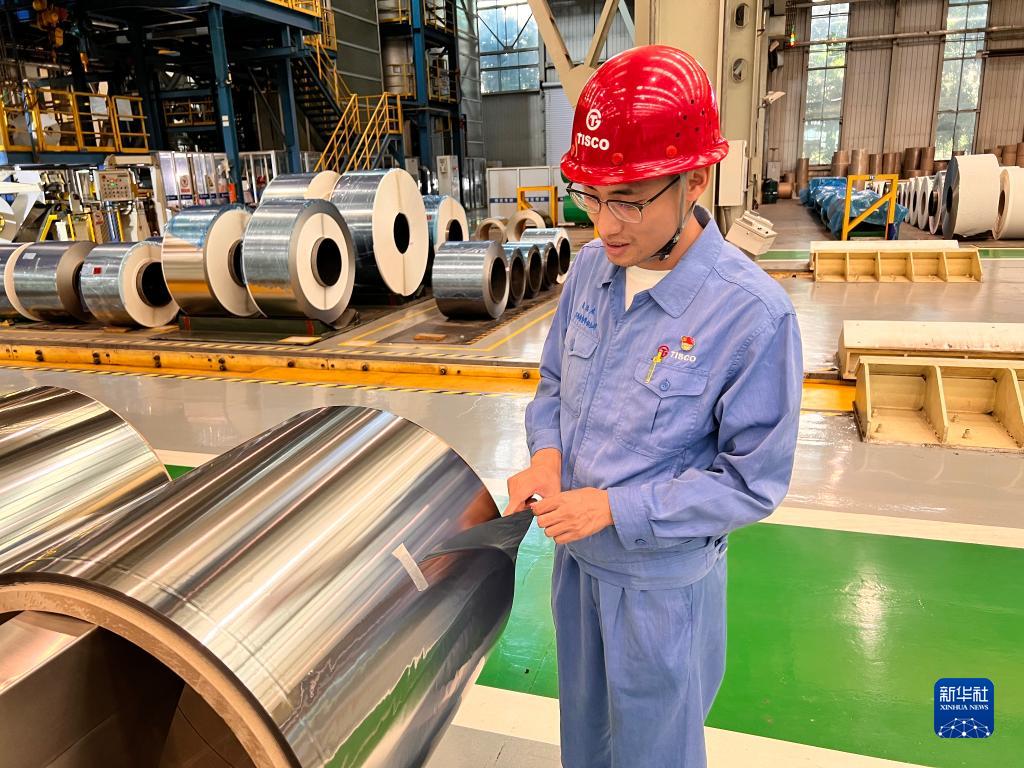 中国宝武太钢精密带钢公司工作人员展示厚度为0.015毫米的“手撕钢”（2022年8月25日摄）。新华社记者 张磊 摄